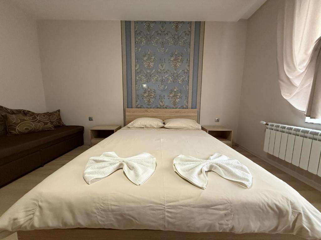a bedroom with a bed with white bows on it at Guest House STEVi in Devin