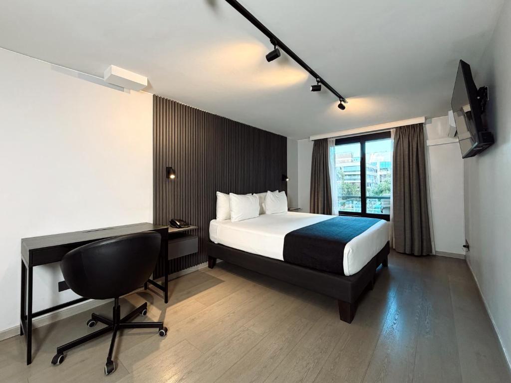 a bedroom with a bed and a desk and a chair at Hotel Tempo Rent in Santiago