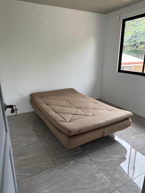 a bed sitting in a room with a window at Apartamentos Zoé in Quebradas