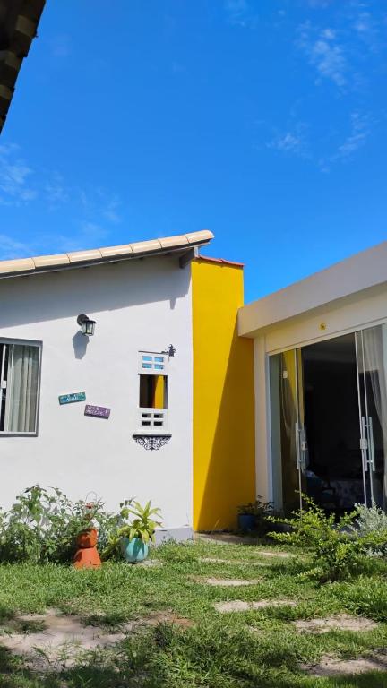 a house with a yellow and white at Villa do Condado in Saquarema
