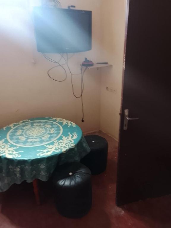 a room with a table and two stools and a television at Premium Services in Tatta
