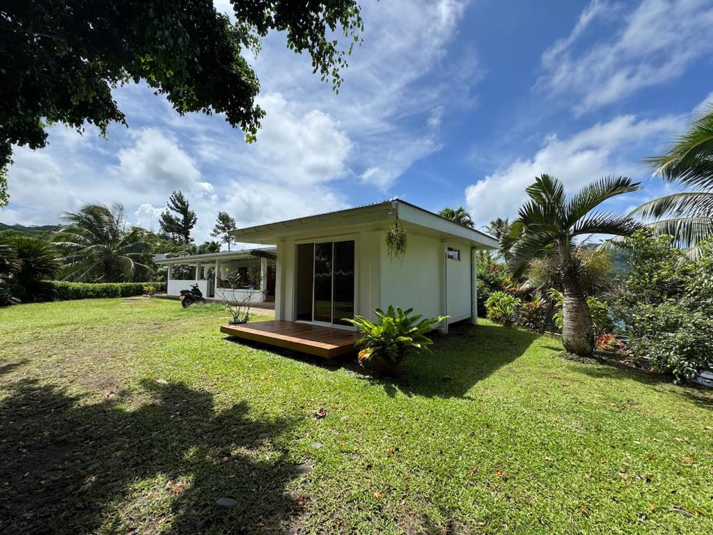 a small house in a field with a yard at Panorama Bungalow in Tahaa
