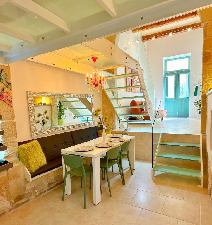 a dining room with a table and green chairs at Dar Divinus - Eat, Wine, Sleep in Rabat