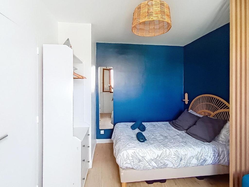 a blue bedroom with a bed with a blue wall at Studio cosy tout équipé, idéal in Chilly-Mazarin