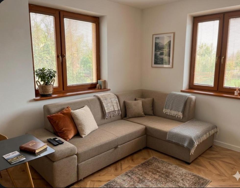 a living room with a couch and two windows at Nido in the center in Poprad