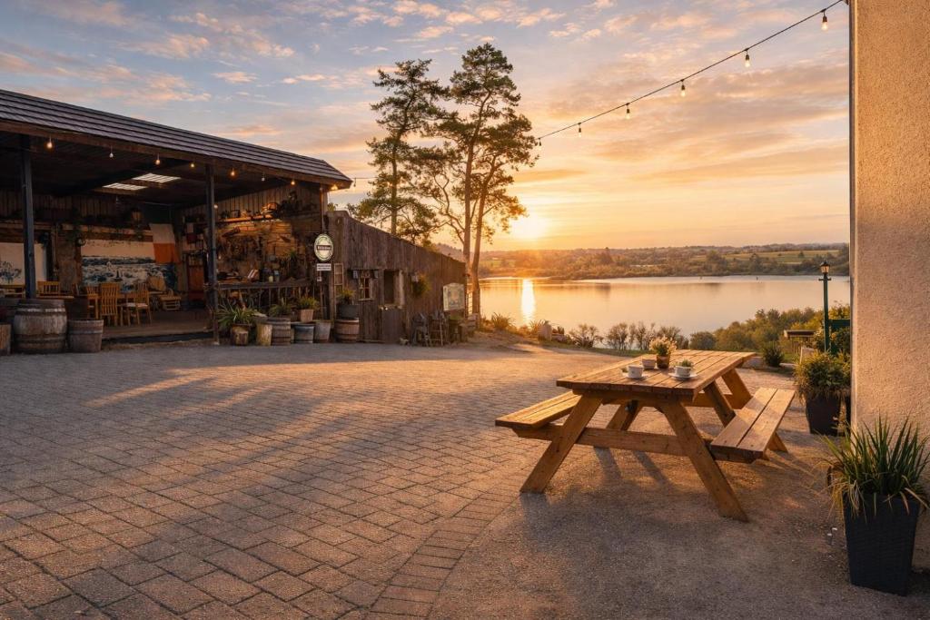 a picnic table in front of a building with a lake at McCormacs Farmhouse in Mullanalaghta
