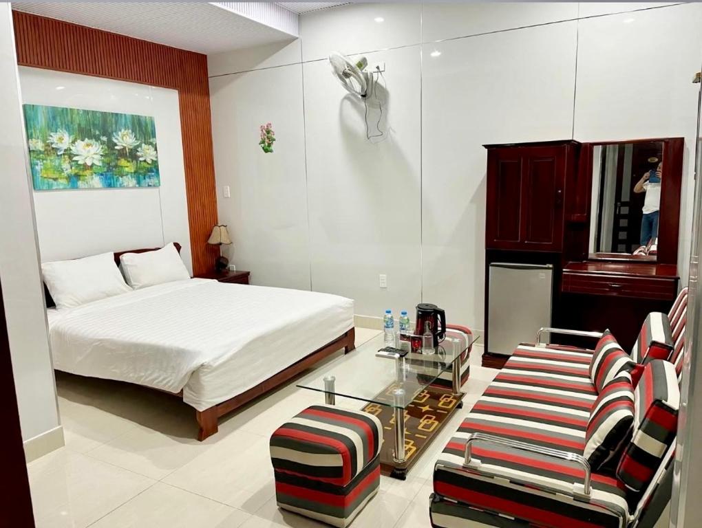 a bedroom with a bed and a table and chairs at Stargazer Hotel in Danang