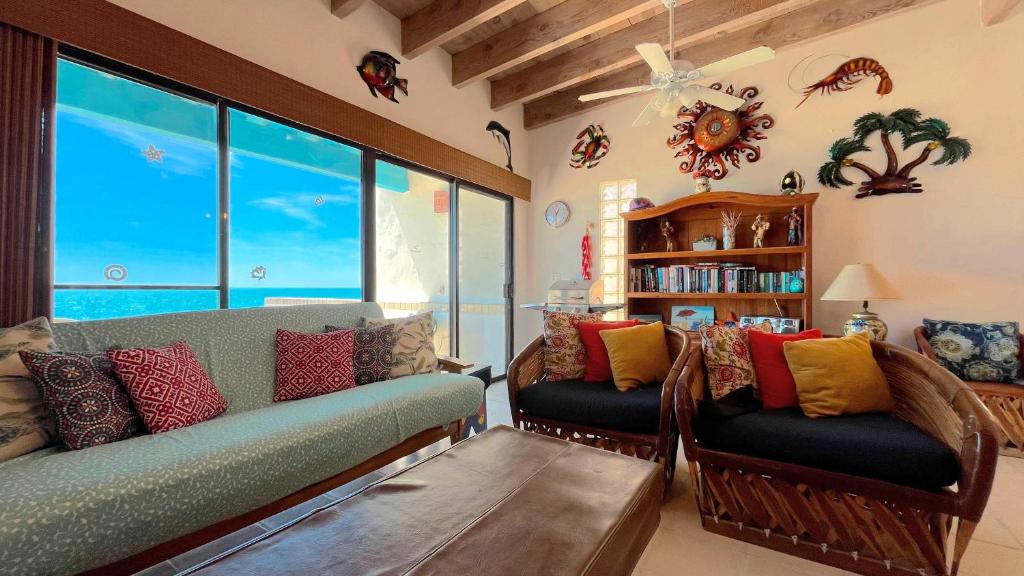 a living room with a couch and some windows at Warm & Charming Beachfront Condo Las Olas II 8 in Puerto Peñasco