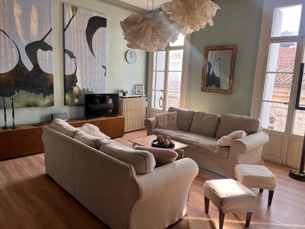 a living room with two couches and a tv at Spacieux et lumineux duplex arty au centre de Sète in Sète
