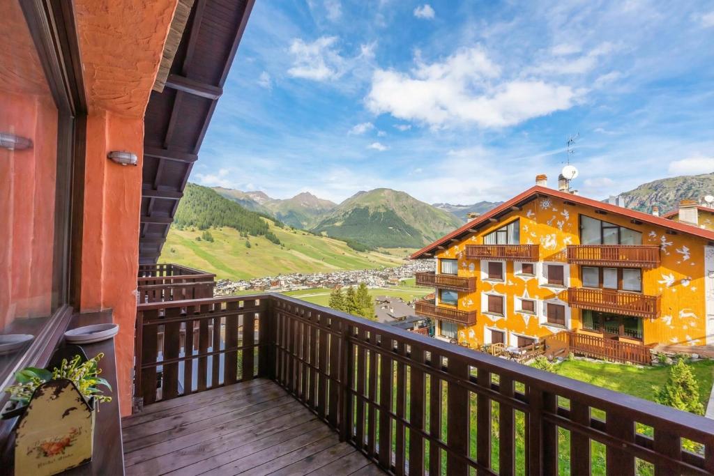 a balcony with a view of a building and mountains at Arianna - Happy Rentals in Livigno