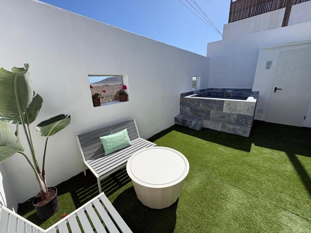 a small room with a tub and green grass at La Casita de Kai in El Médano