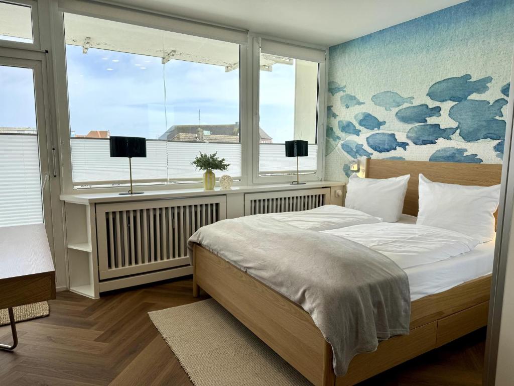 a bedroom with a bed and two windows at Boje in Westerland