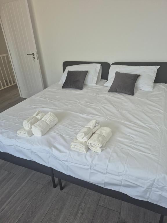 a large white bed with three towels on it at One bed flat in UB5 in Northolt