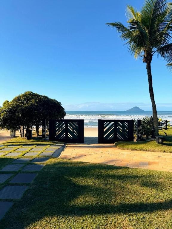 a palm tree and a bench on the beach at Condo-Resort Juquehy, 4 quartos, em frente ao mar in São Sebastião