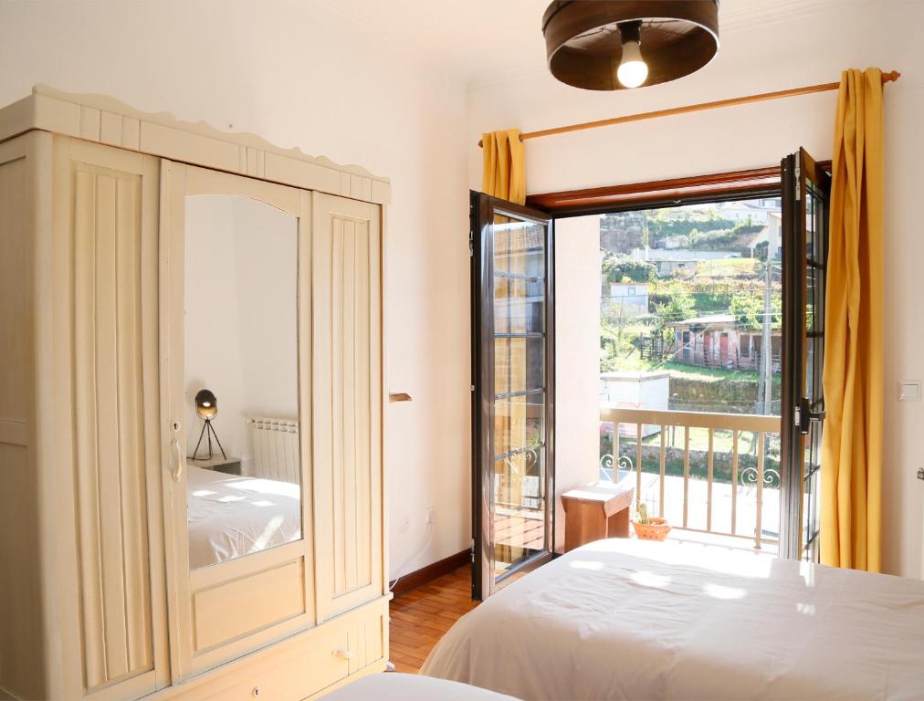 a bedroom with a bed and a large window at Casa Pedravedra in Mondim de Basto