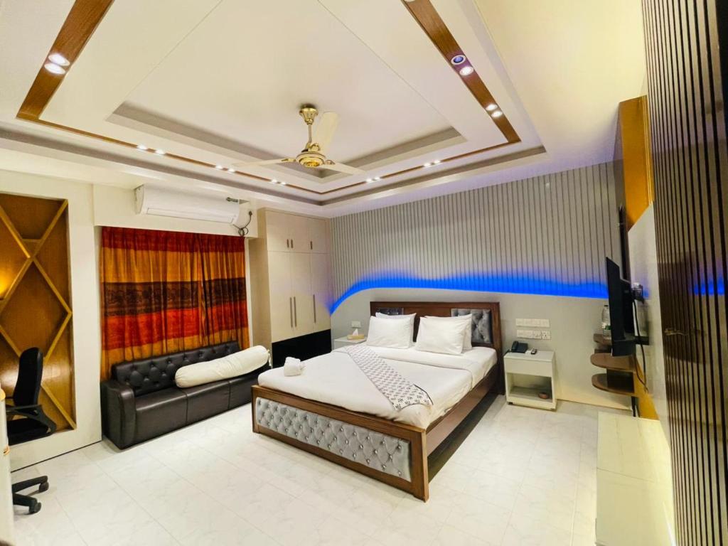 a bedroom with a large bed and a couch at Rainbow Guest House in Sylhet