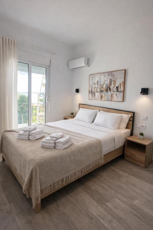 a bedroom with a large bed with towels on it at Eleni`s apartment Gialova, Giorgos House in Gialova