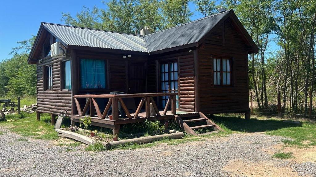 a log cabin with a metal roof and a porch at La Escondida in Estación Monte
