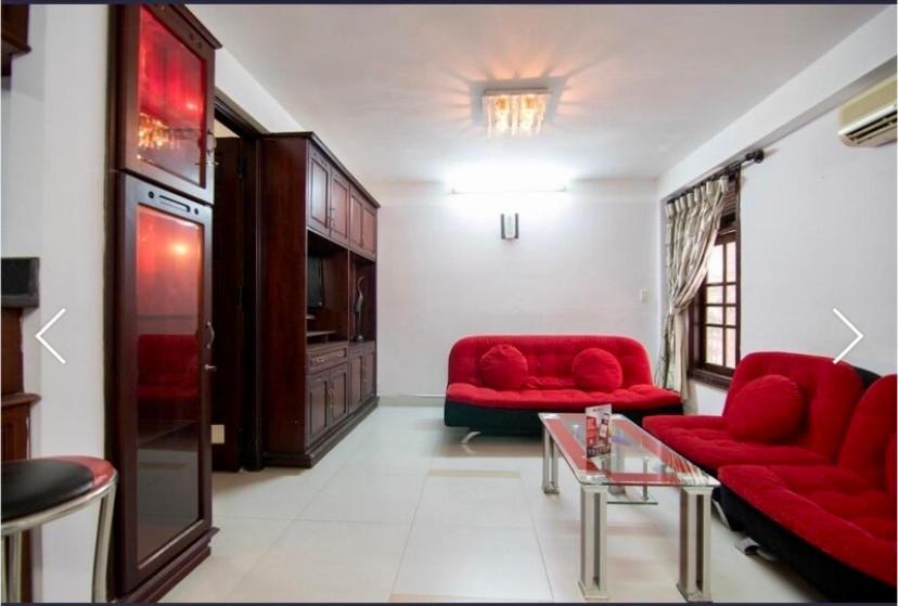 a living room with two red couches and a table at Stargazer Hotel in Danang