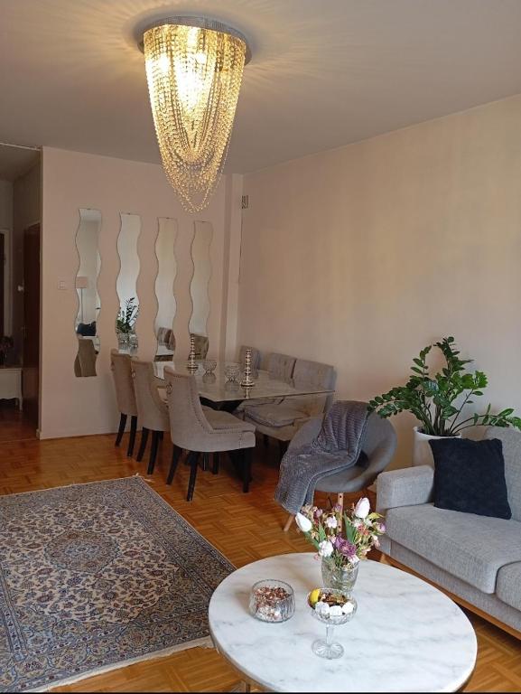 a living room with a chandelier and a table and chairs at Karlskrona centrum in Karlskrona