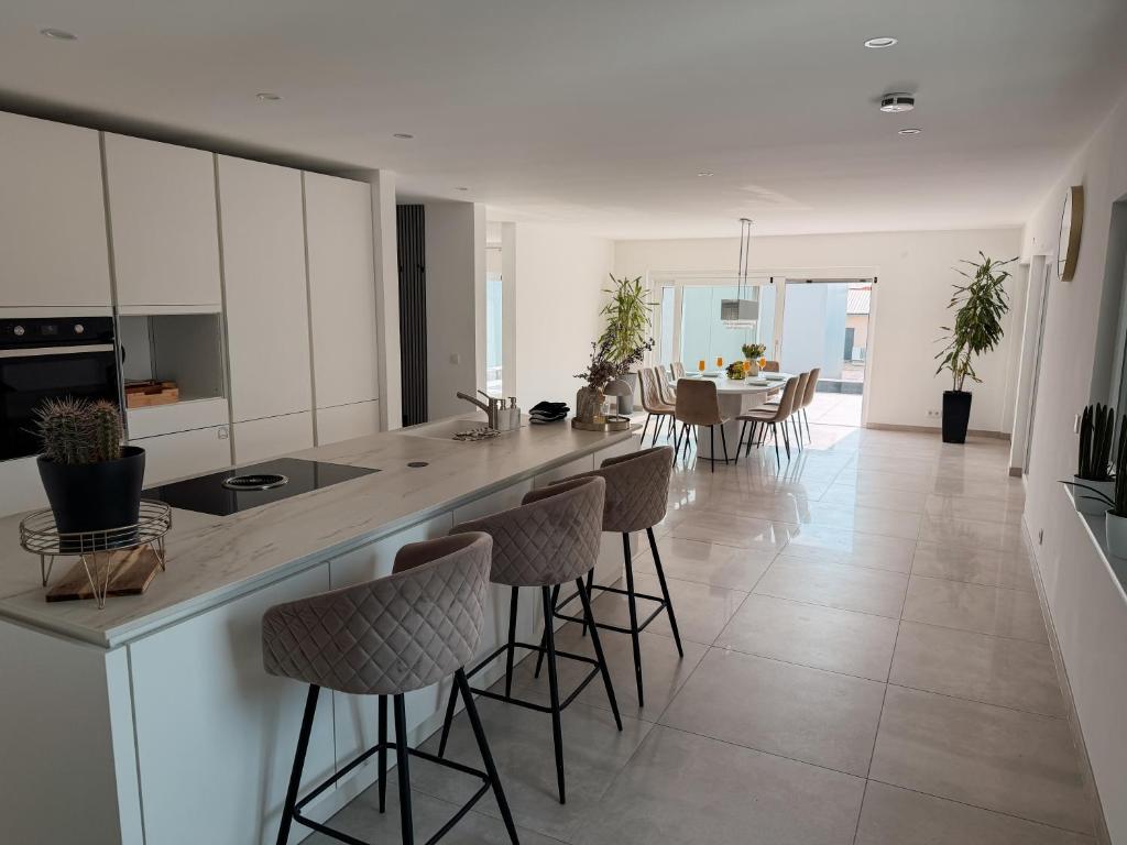 a kitchen and dining room with a counter and chairs at Luxury Apartments Marz in Schwanau