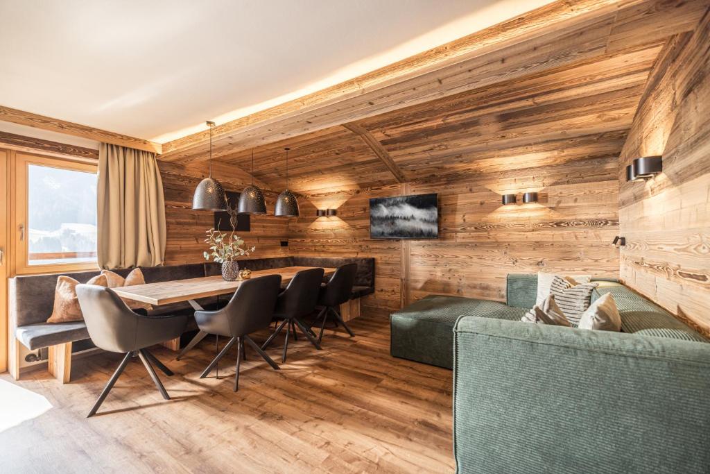 a living room with wooden walls and a table and chairs at Haus Barbara in Alpbach