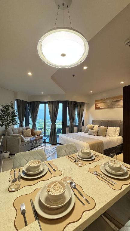 a living room with a table and a bed at 12th Floor Studio Tambuli, Sea View, Balcony in Maribago