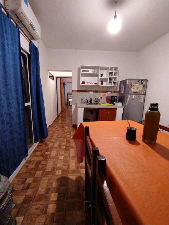 a kitchen with a table and a kitchen with a refrigerator at Lo del Tata in Villa Unión
