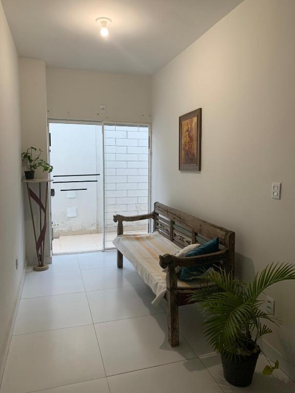 a living room with a bench and a large window at Apartamento do Sol in Diamantina