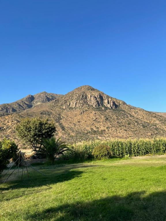 a mountain in front of a green field with a hill at Casa Ordóñez - Cielo Abierto in El Molino
