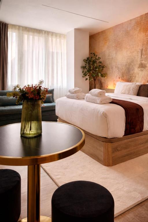 a hotel room with two beds and a table at Miriam by Dozzze in Madrid