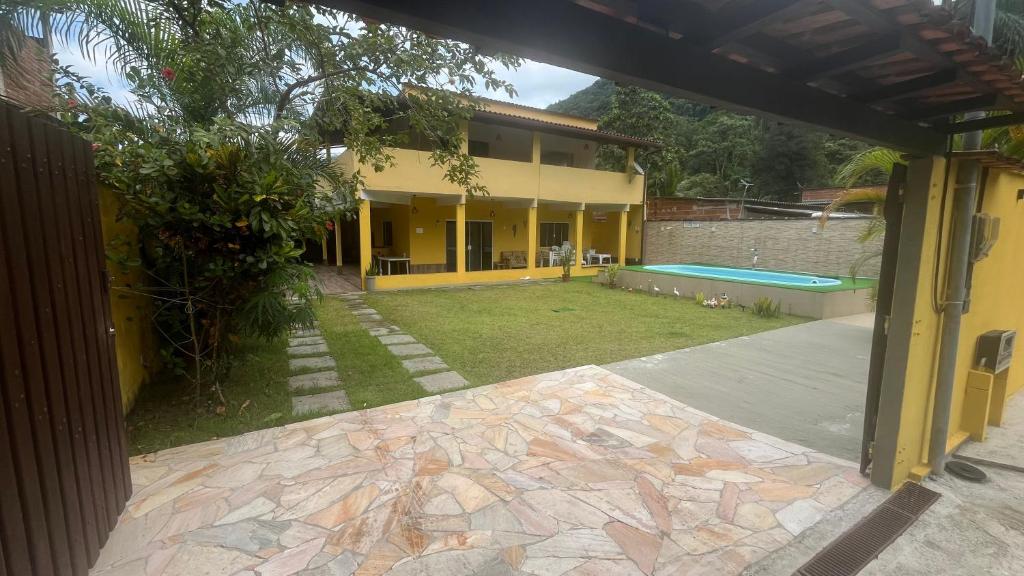 an outside view of a house with a yard at Casa com churrasqueira e piscina, perto de riacho in Angra dos Reis