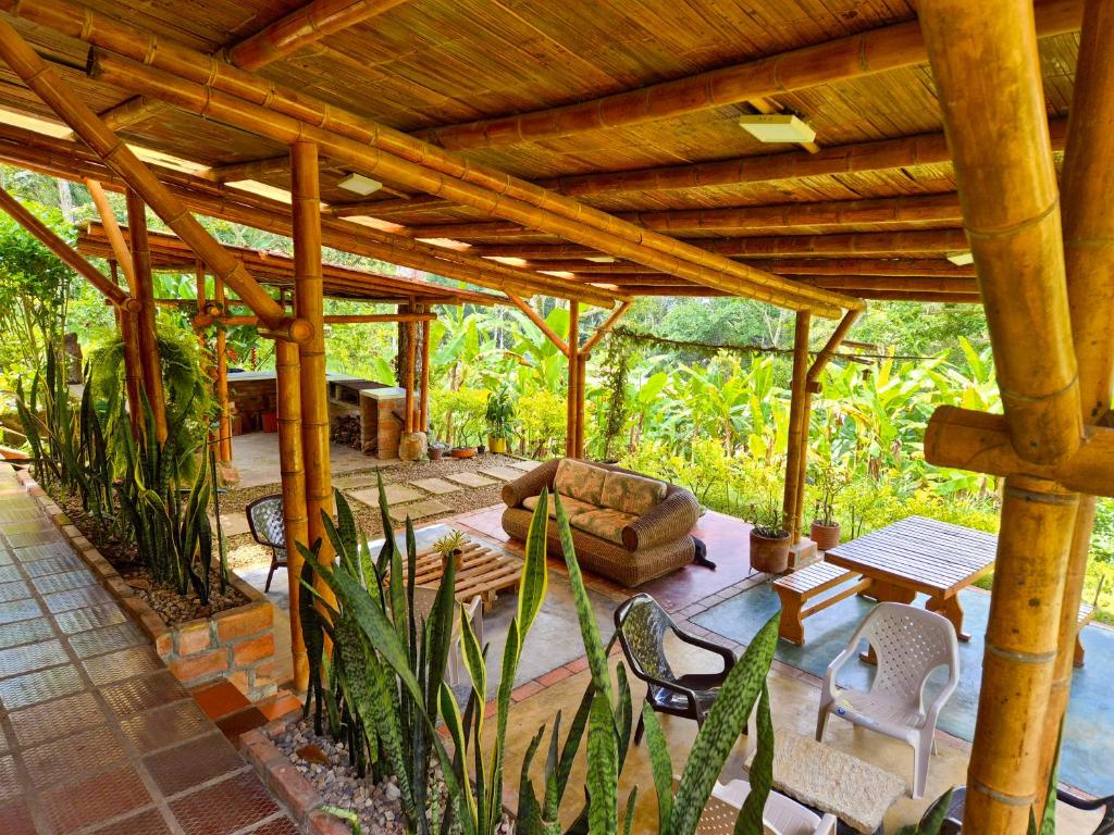 a covered patio with a couch and a table and chairs at Cabaña Campestre de Descanso in Melgar