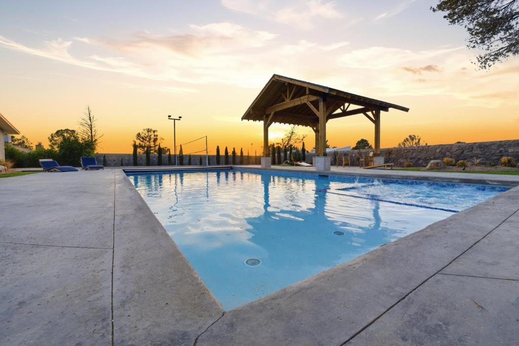 a swimming pool with a wooden gazebo at Private Beach Volleyball Pool Retreat in Las Cruces