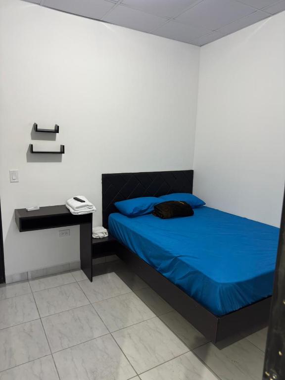a bedroom with a blue bed and a desk at Tu refugio en el corazon de David in David