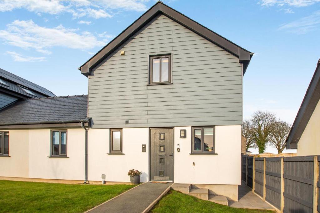 a house with a grey and white facade at 3 Bed in Brynteg oc-d33659 in Brynteg