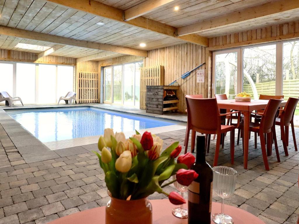 a house with a pool and a table with flowers at Annexe in Sourbrodt