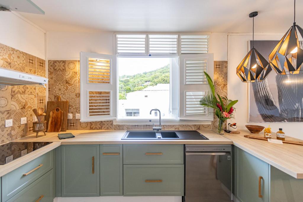 a kitchen with blue cabinets and a sink and a window at Pointe Noire in Pointe-Noire