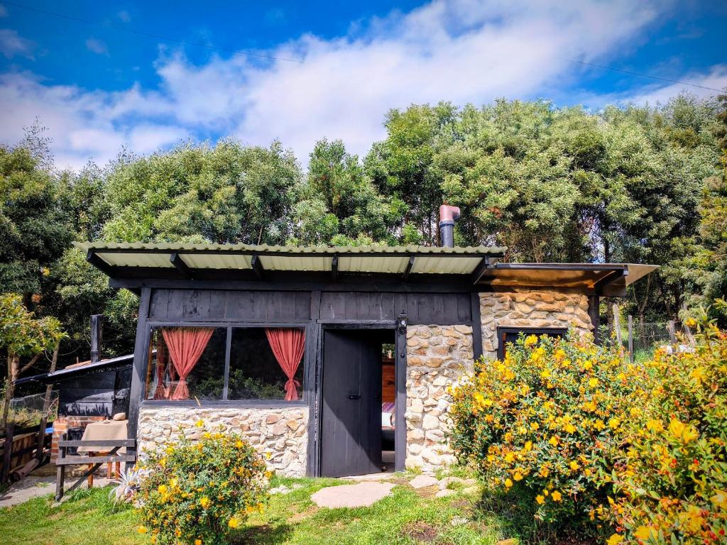 a small stone building with a roof at Chalet Stonehenge in Pasto