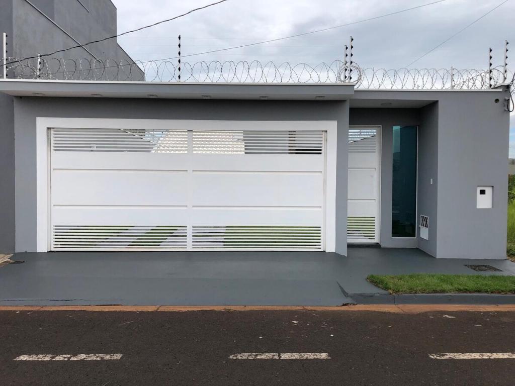 a white garage door on the side of a house at Laranjeiras House in Uberaba