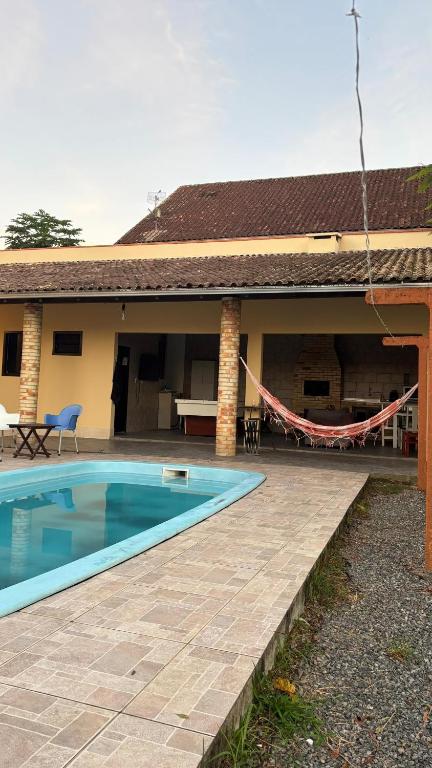a house with a swimming pool in front of it at Econômica Joinville Hostel e Pousada in Joinville