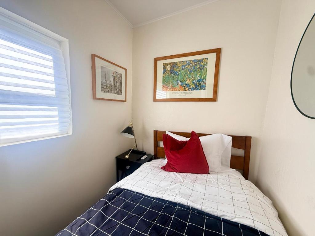 a bedroom with a bed with two red pillows at 7A - A Diamond in Yonkers in Yonkers