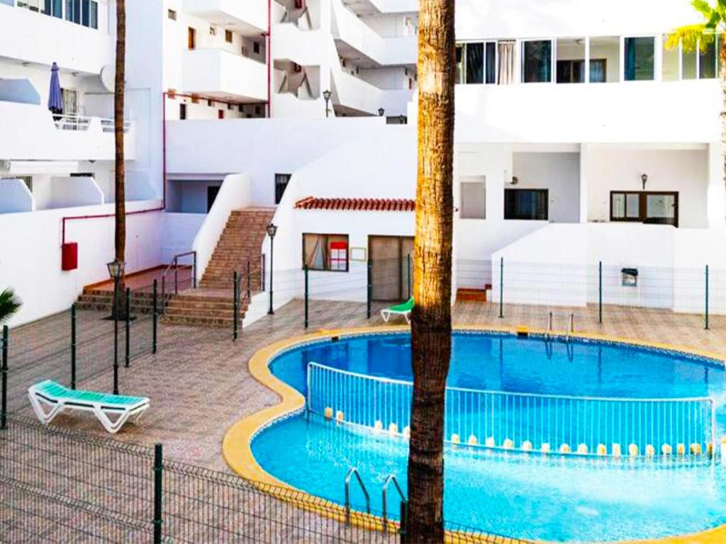 an outdoor swimming pool with a building at Modern Studio with Pool & Terrace Playa de las Américas, Tenerife in Playa de las Americas