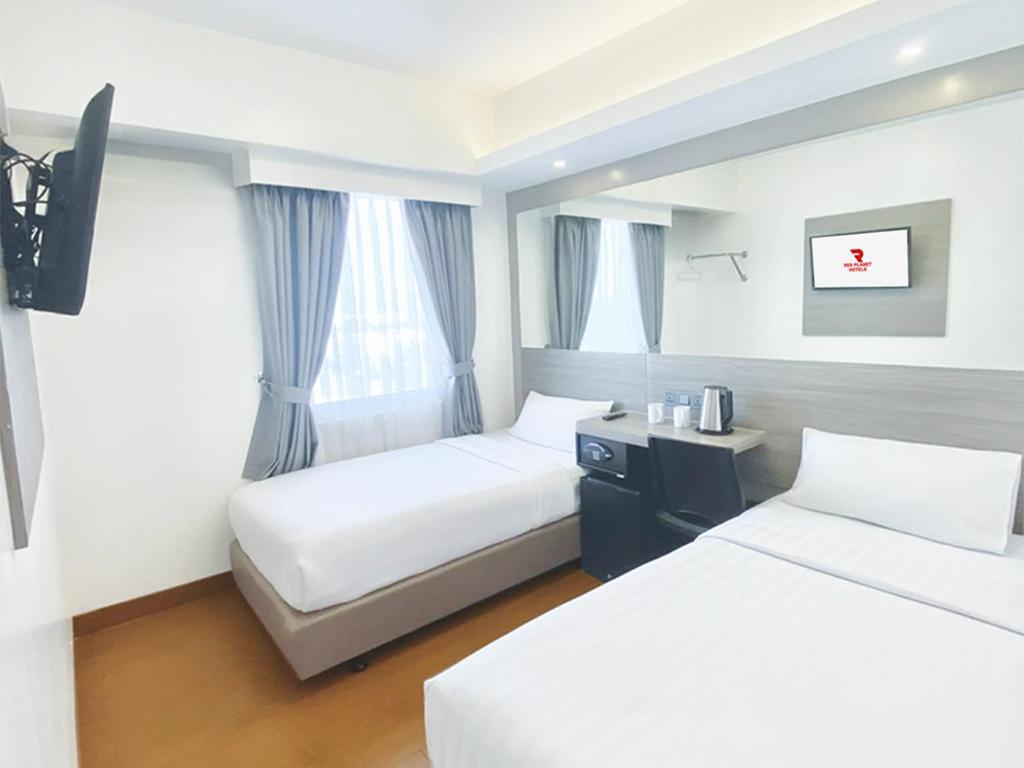 a hotel room with two beds and a window at Red Planet Cebu in Cebu City