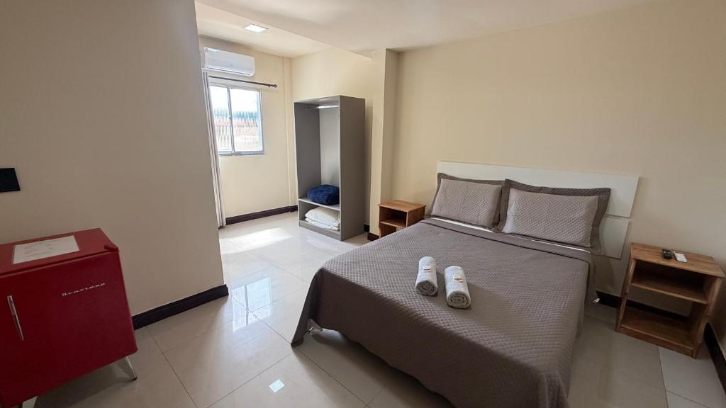 a bedroom with a bed with two shoes on it at Caminho de Itacoatiara in Niterói