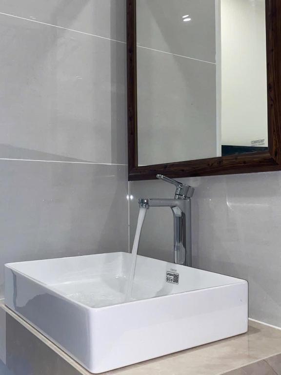 a white sink in a bathroom with a mirror at Luxury Hotel Long Thành in Xóm Nước Trong
