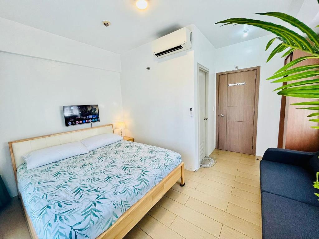 a bedroom with a bed and a tv on the wall at Kings hotel Ph in Manila