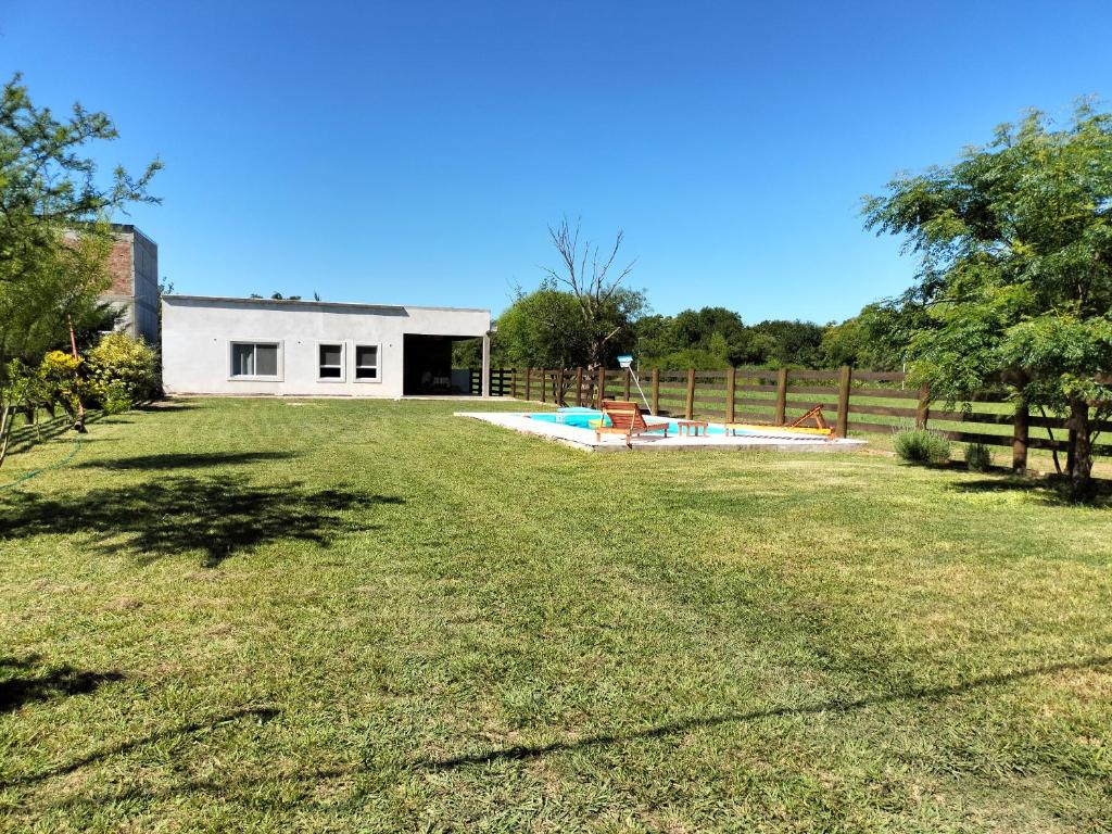 a yard with a white building and a pool at El Chiringuito in Paraná