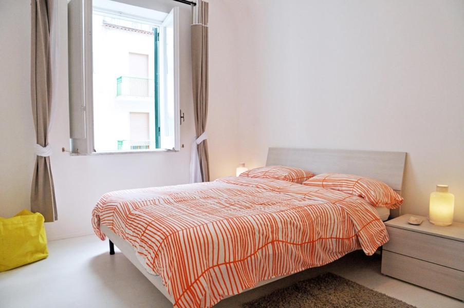 a white bedroom with a bed and a window at Sciù Sciù House in Atrani