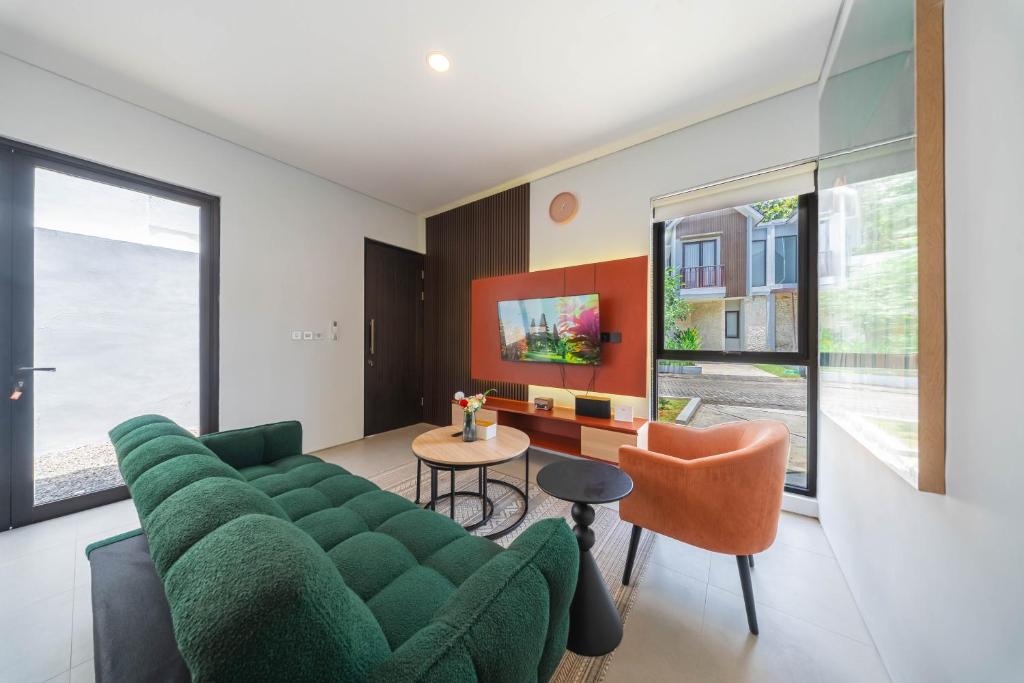 a living room with a green couch and orange chairs at Villa Vatama Jimbaran in Jimbaran